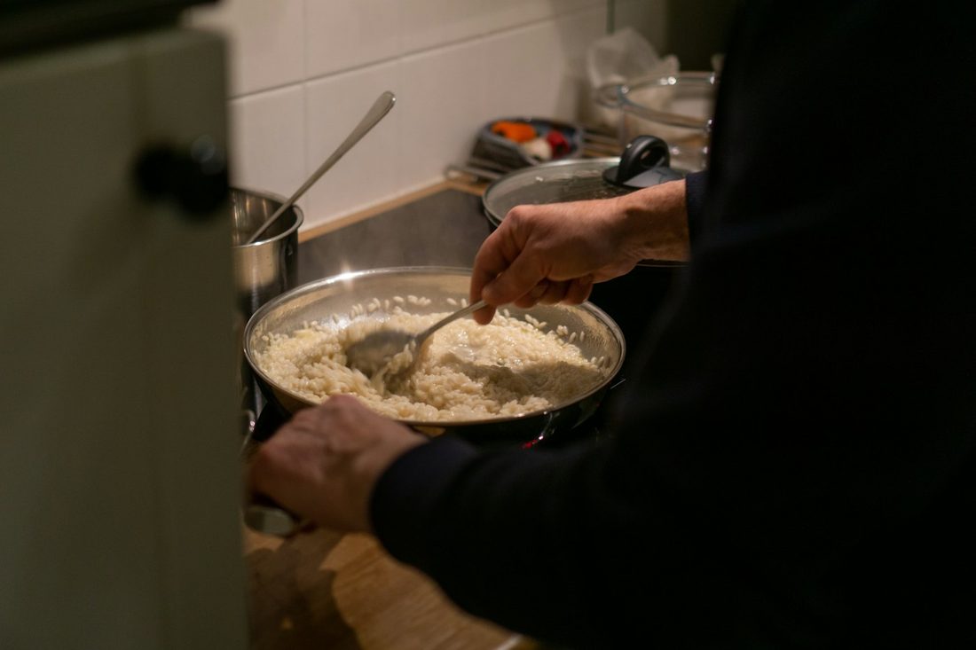 Chef mexendo o risoto na panela