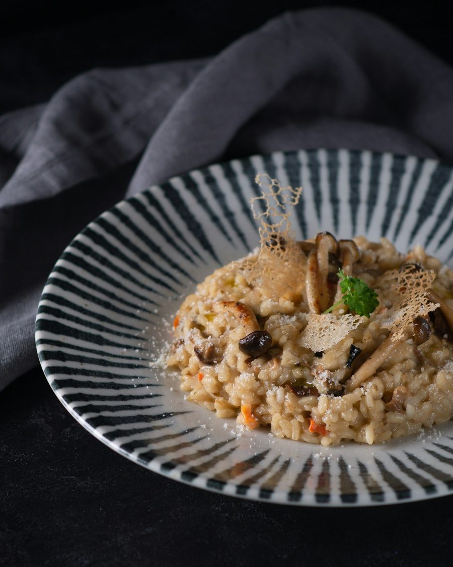 Risoto de cogumelos em prato listrado